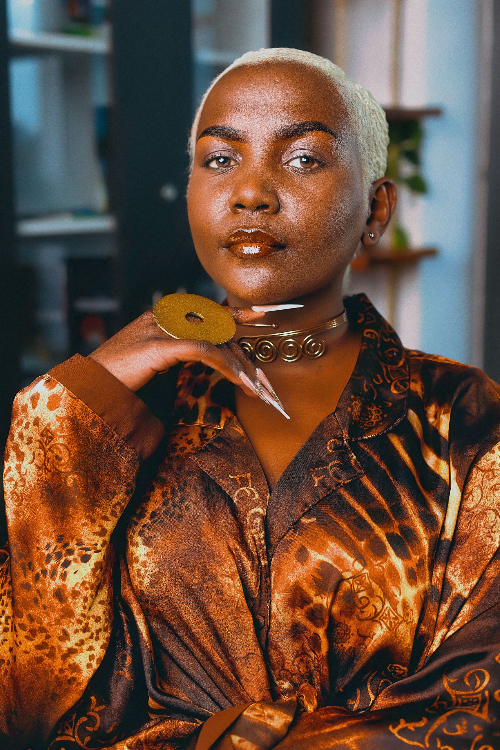 A woman in profile wears a large sculptural earring.